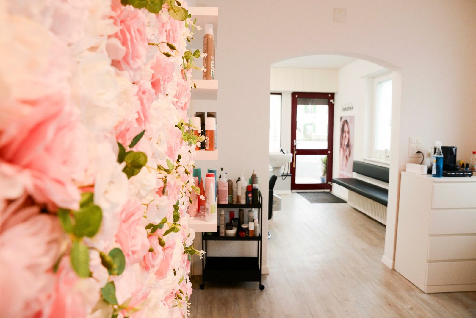 Wand aus rosa Rosen, dahinter der helle Salon mit Blick zur Eingangstür